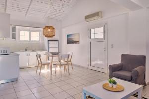 eine Küche und ein Wohnzimmer mit Tisch und Stühlen in der Unterkunft Villa Nefeli Periyali in Vasilikos