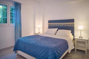 ein Schlafzimmer mit einem großen Bett mit einer blauen Decke in der Unterkunft Villa Nefeli Periyali in Vasilikos + 13 Fotos