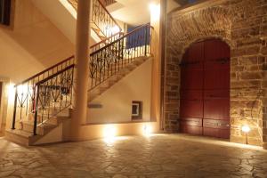 un pasillo con escaleras y una puerta roja en Avgerinos Hotel, en Kambos