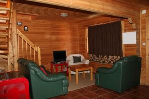 Sala de estar con 2 sillas verdes y TV en Cota 1500 - Chalé 32 - Penhas da Saúde, en Penhas da Saúde