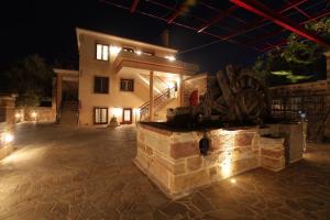 a stone fireplace in front of a house at night at Avgerinos Hotel in Kambos