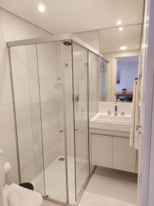 een badkamer met een glazen douche en een wastafel bij Solar Tambau Residencial in João Pessoa