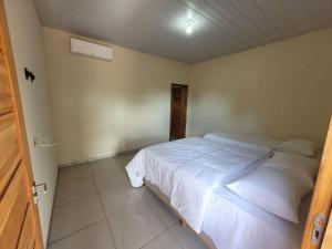 een slaapkamer met een groot wit bed in een kamer bij Pousada do Gael in Estivado