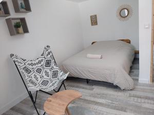 a small bedroom with a bed and a chair at Duplex familial 2 chambres Disney Paris CDG in Annet-sur-Marne