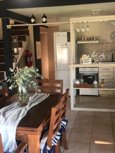 a kitchen with a table with a vase of flowers on it at LunaNegra Casas de descanso in Villa General Belgrano +28 photos