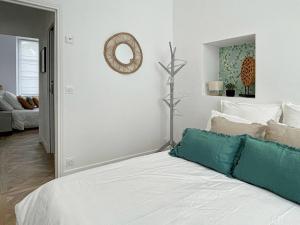 Un dormitorio con una cama blanca y un espejo. en Le Grand Carré Versailles, en Versalles