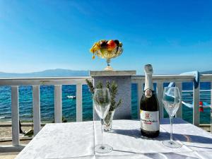 een fles wijn op tafel met twee glazen bij Apartments Tomo in Zaostrog