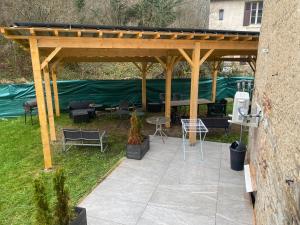 a wooden pergola with a table and chairs at Logement à Dijon nord in Velars-sur-Ouche