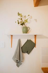 a white shelf with a plant on a wall at The Loft House in Graaff-Reinet