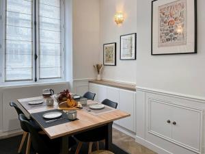 a dining room with a wooden table and chairs at Le Grand Carré Versailles in Versailles