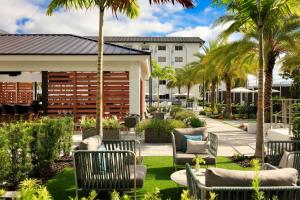 a patio with chairs and palm trees and a building at Renaissance Boca Raton Hotel in Boca Raton