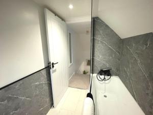 une salle de bain avec une douche avec une porte vitrée dans l'établissement Pass the Keys Beautifully Presented Cosy Town Centre Cottage, à Dumfries 18 autres photos