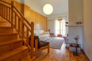 a living room with a staircase and a couch at LEA's HOME - Cozy Chalet with Mountain View in Vytina