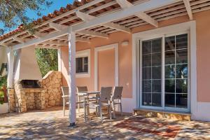 a patio with a table and chairs under a pergola at Villa Cleo Periyali in Vasilikos