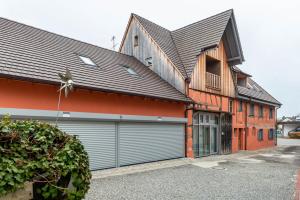 a house with two garage doors in front of it at Apartments im Gästehaus Krone in Bodman-Ludwigshafen