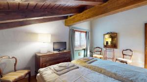 a bedroom with a bed and two chairs and a television at Ste 10 in Celerina