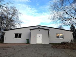 a white building with a white door on it at Baraczek Lotnisko Leszno in Leszno