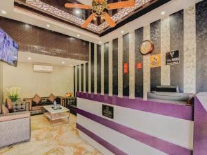 a lobby with a clock and a waiting room at Capital O Good Luck Residency Hotel in Guwahati +36 photos