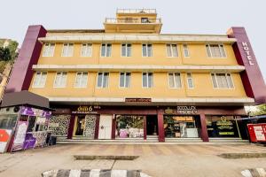 a yellow building with a tower on top of it at Capital O Good Luck Residency Hotel in Guwahati