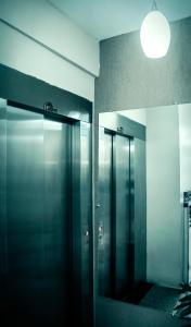Dois elevadores numa casa de banho com espelho em Hotel Pais e Filhos em São João del Rei