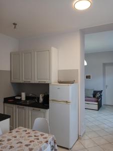 a kitchen with a white refrigerator and a table at Giardino delle Ortensie in Cannobio