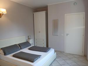 a white bedroom with two beds and a closet at Giardino delle Ortensie in Cannobio +21 photos