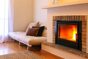 a living room with a fireplace and a couch at VYTINA LOFTS - Cozy 2-Level Loft Apartments with Fireplace & Mountain Views in Vitina