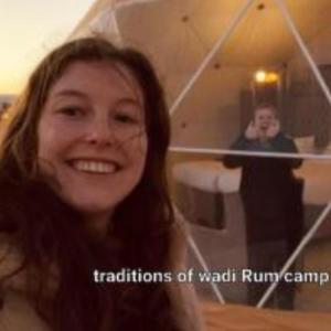 a woman is smiling in front of a mirror at Traditions of Wadi Rum camp & jeep tour in Wadi Rum
