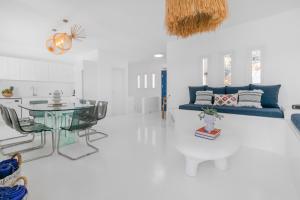 a living room with a glass table and a blue couch at Island Riviera Mykonos Villa in Agios Sostis Mykonos