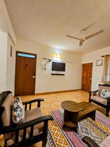 a living room with a couch and a tv on the wall at 2BHK Modern Apartment in Colva