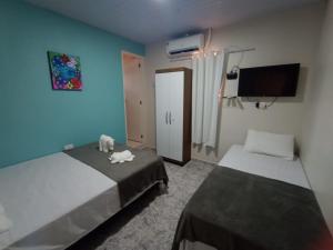 a bedroom with two beds and a blue wall at Suites Mar Azul- São José - Maragogi in São José da Coroa Grande