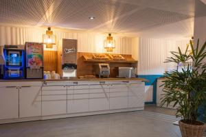 a kitchen with a counter with aasteryasteryasteryasteryasteryasteryasteryasteryastery at The Originals Résidence Paris Sud Villejuif in Villejuif