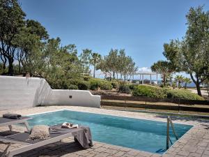 een zwembad met een chaise longue naast bij Villa Artemis Periyali in Vasilikos