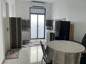 a kitchen with a table and a kitchen with a refrigerator at Yanaya Stay in Male City