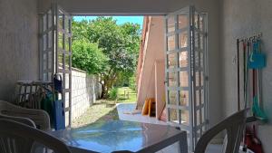an open door to a patio with a table and chairs at Casa Espaçosa a 200m da praia in Florianópolis