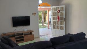 a living room with a couch and a flat screen tv at Casa Espaçosa a 200m da praia in Florianópolis