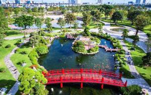 a red bridge over a river in a park at Hana homestay 1 phòng ngủ tại Vinhome Central Park in Ho Chi Minh City +4 photos