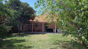 a house with a garden and a yard with trees at Casa Espaçosa a 200m da praia in Florianópolis