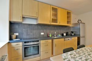 a kitchen with wooden cabinets and stainless steel appliances at Monteurwohnung Tobias Suhl in Suhl