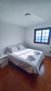 a bedroom with a large white bed with a window at Vv La Marina in Santa Cruz de la Palma