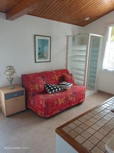 un sofá rojo sentado en una sala de estar en maison île de Ré avec piscine chauffée et vélos, en Le Bois-Plage-en-Ré 14 fotos más