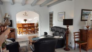 sala de estar con muebles de cuero negro y comedor en maison île de Ré avec piscine chauffée et vélos, en Le Bois-Plage-en-Ré
