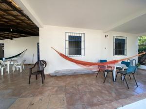 a hammock in a room with chairs and a table at Casa do Bosque in Camaçari