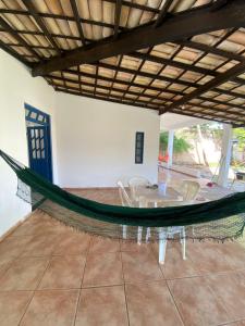 a hammock in a room with a table and chairs at Casa do Bosque in Camaçari