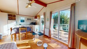 a kitchen and living room with a table and a balcony at La Paranthese Marine in Brem-sur-Mer