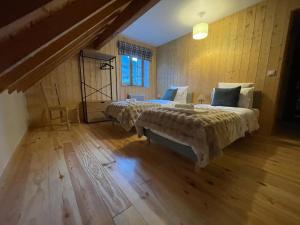Un dormitorio con dos camas y suelo de madera. en Oisans Vacances Gîte Vermarine, en Allemont