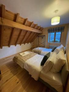 1 dormitorio con 2 camas en una habitación con suelo de madera en Oisans Vacances Gîte Vermarine, en Allemont
