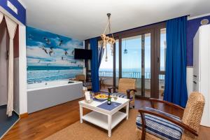 a living room with a view of the ocean at Hotel Kalura in Cefalù