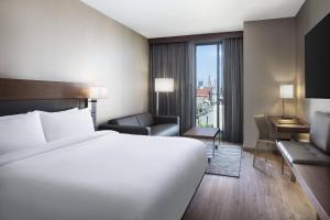 a hotel room with a large white bed and a desk at AC Hotel by Marriott Louisville Downtown in Louisville +35 photos