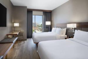 a hotel room with two beds and a desk at AC Hotel by Marriott Louisville Downtown in Louisville